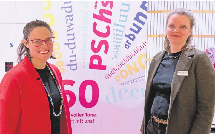 Carla Branca Behle (links) und Linda Loosli vor dem Jubiläumsplakat: Mit «Laaaliiiluuuu» und «Du-duwaduu» ins 60. Jahr.