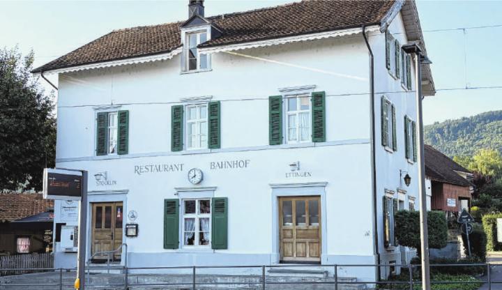 Das Restaurant Bahnhof in Ettingen mit der neu installierten Bahnhof-Uhr: Die Fassade trägt nun eine funkgesteuerte Uhr, gestiftet vom Kulturhistorischen Verein Ettingen. Foto: Urs Haensli, Ettingen